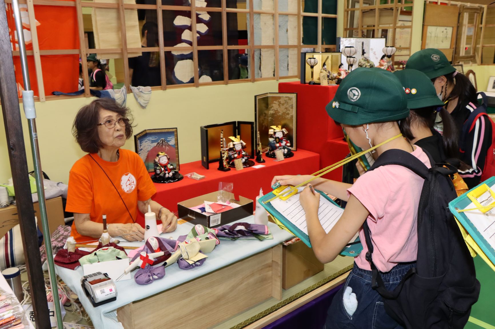 衣裳着人形の説明を聞く小学生