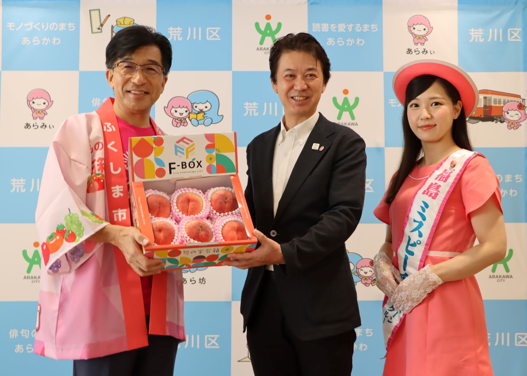 木幡市長とミスピーチから桃の贈呈