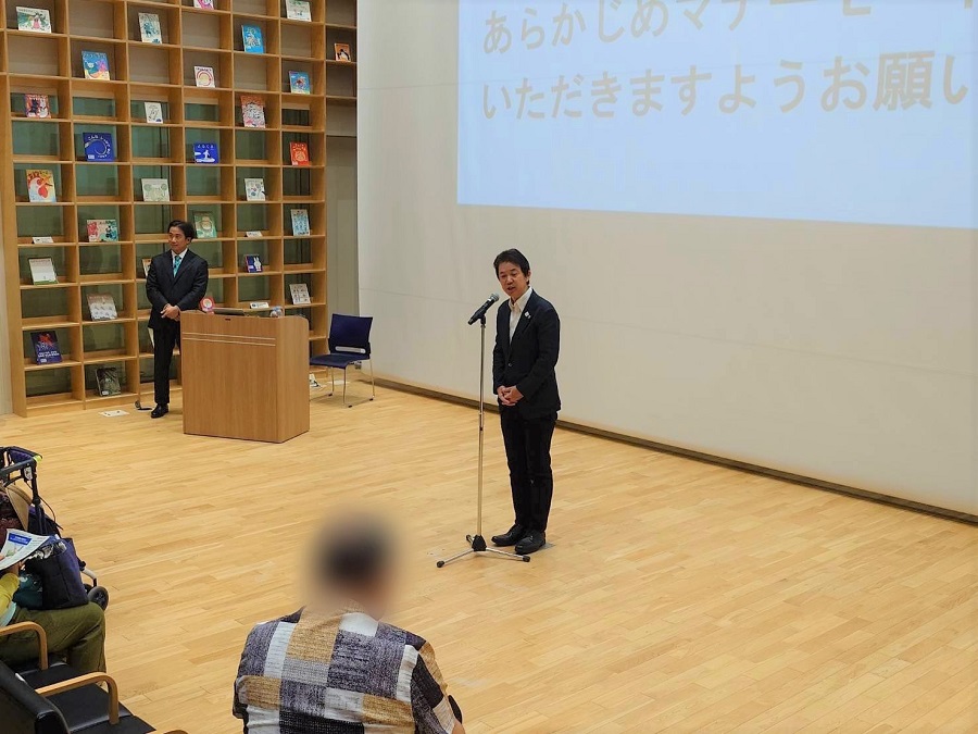 講演会であいさつをする区長