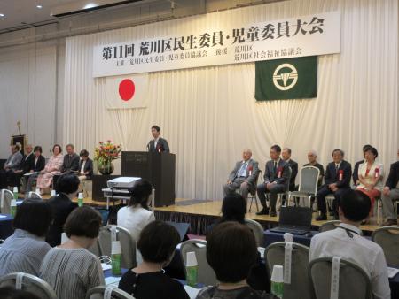 みんせいいいんじどういいん大会で挨拶をする区長