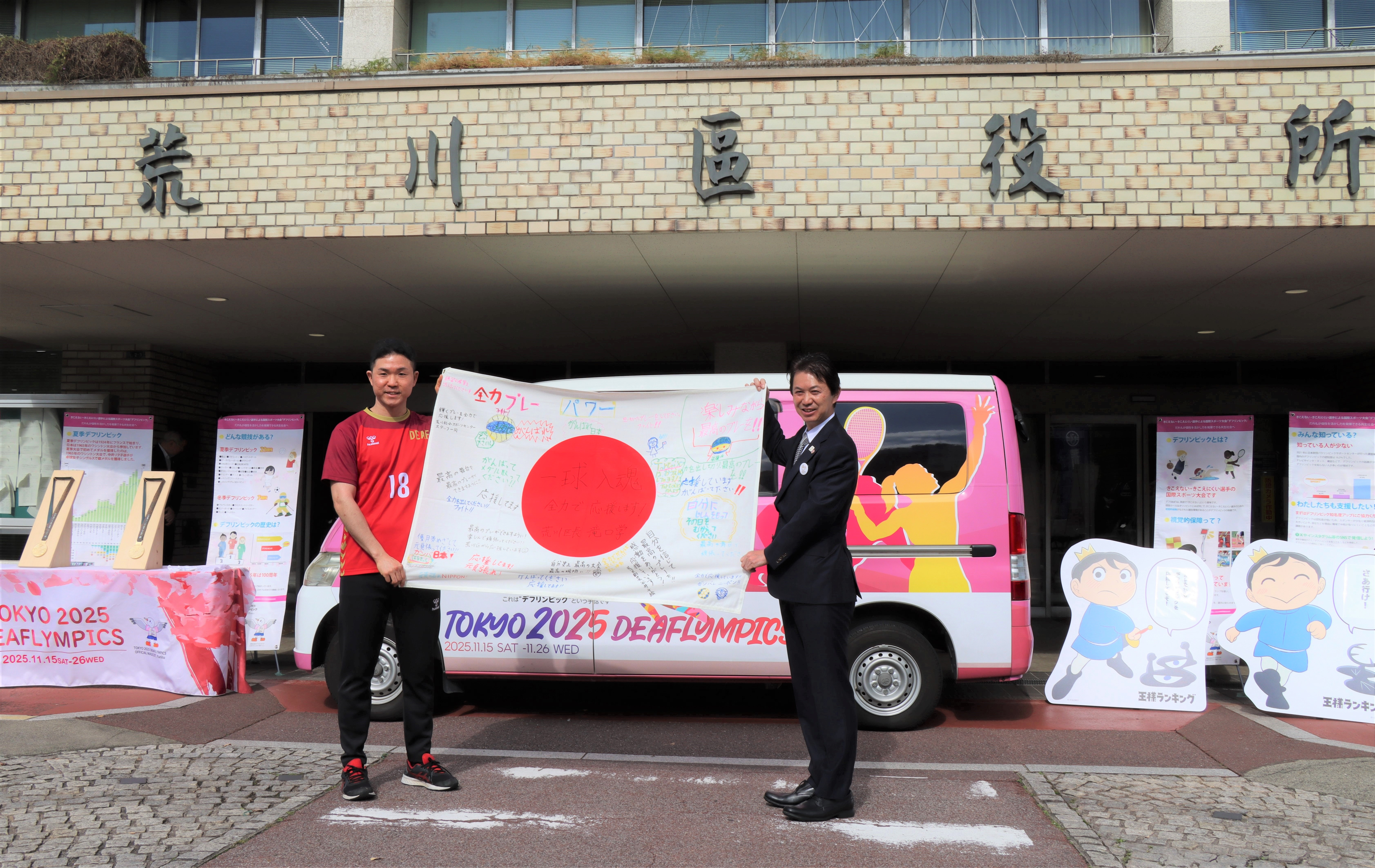 寄せ書き国旗を持つ翁選手（左）と滝口区長