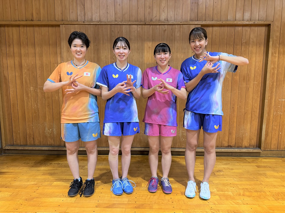 デフリンピック卓球女子団体戦に参加する選手4名がデフリンピックのポーズをしている写真